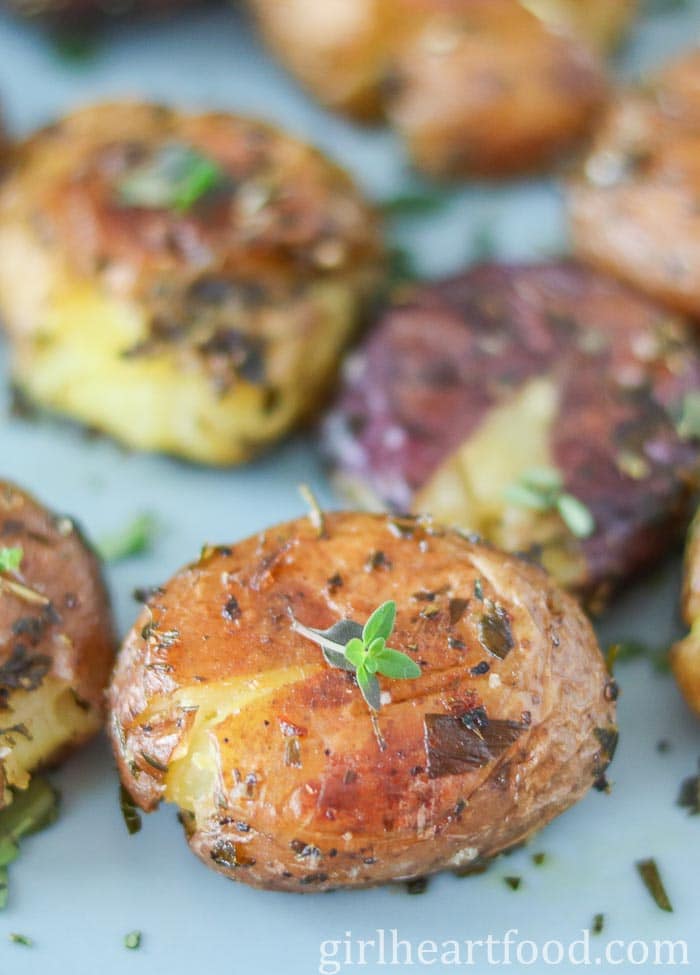 Close-up of a smashed roasted baby potato with thyme.
