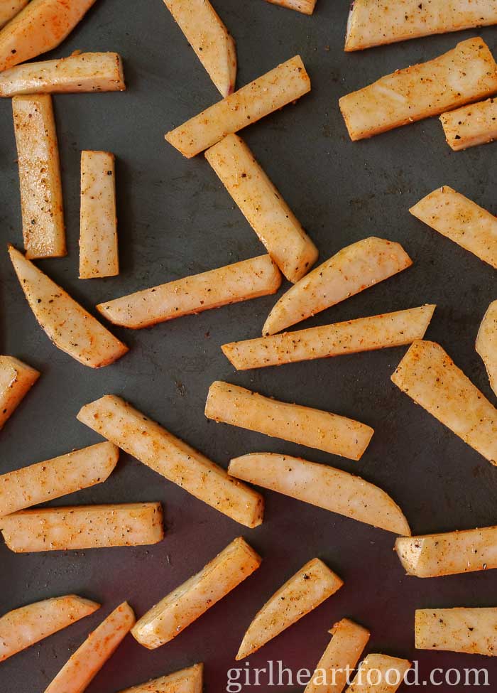 Turnip fries on a sheet pan before being baked.
