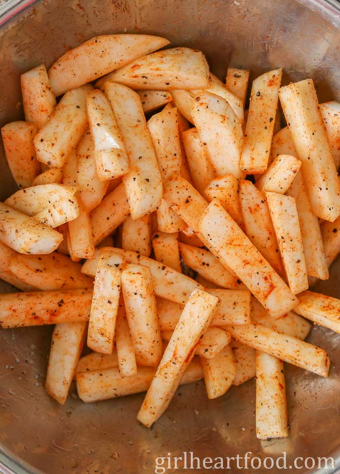 Spiced turnip fries in a bowl before going in the oven.
