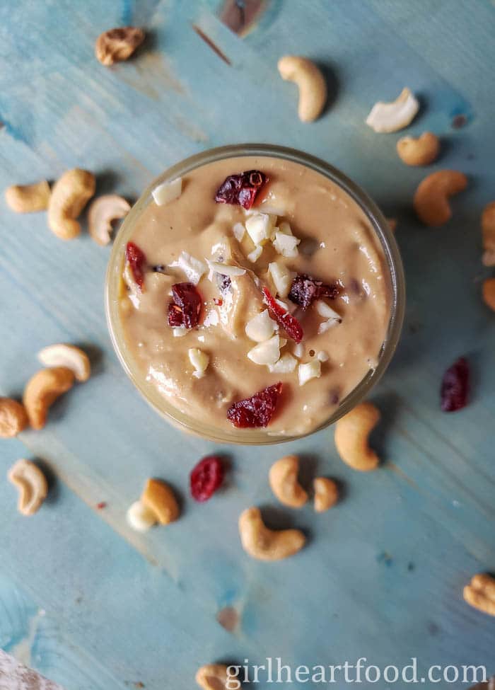 Jar of cashew nut butter with white chocolate and dried cranberries.