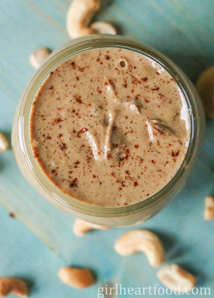 Jar of chai cashew butter with cinnamon sprinkled on top.