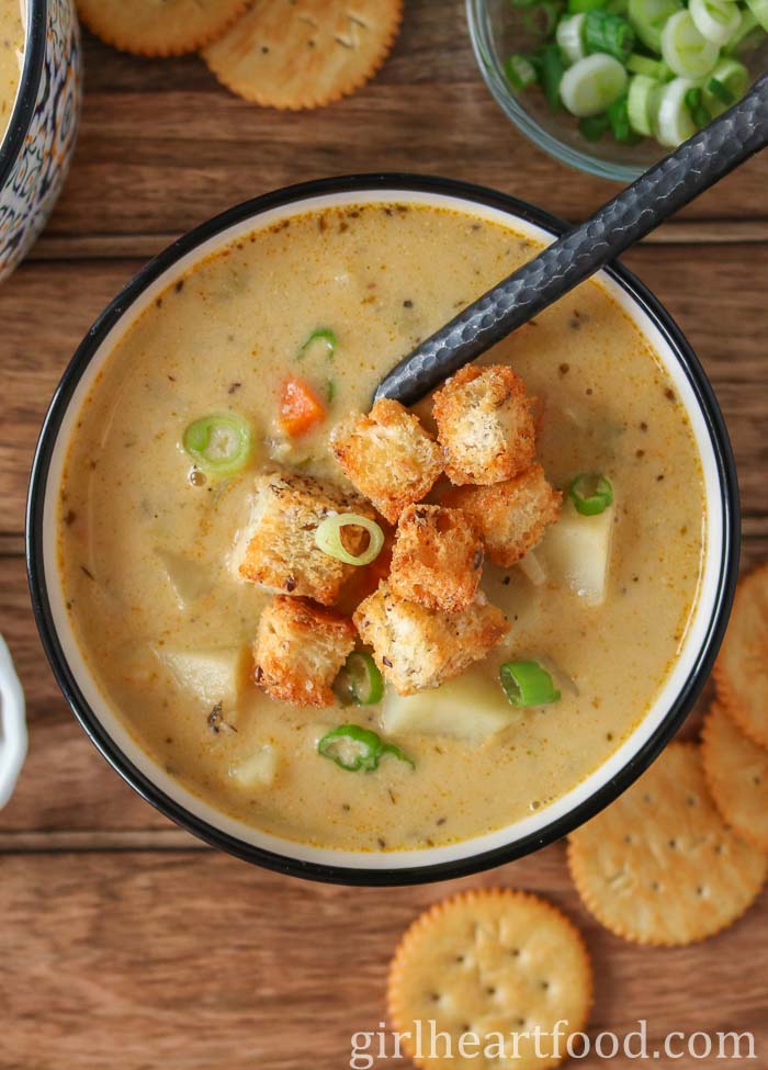 Bowl of celery root soup topped with croutons and green onion.