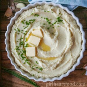 Celeriac puree in a dish topped with chives and butter.