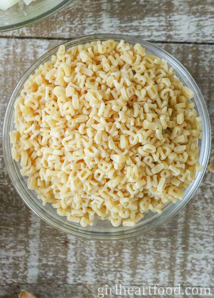 Bowl of uncooked alphabet pasta.