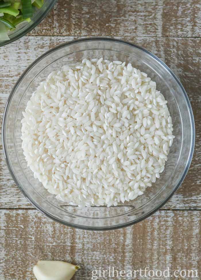 Uncooked arborio rice in a glass bowl.