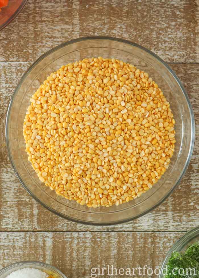 Glass bowl of uncooked split mung beans.