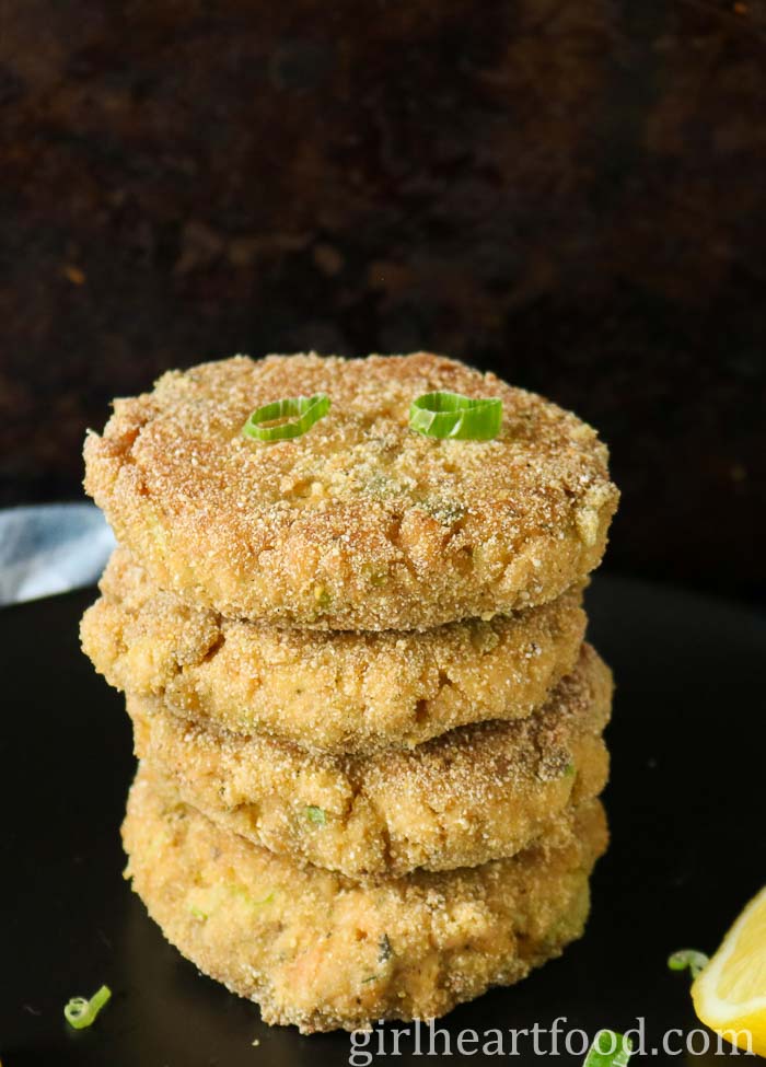 Stack of four salmon cakes garnished with green onion.