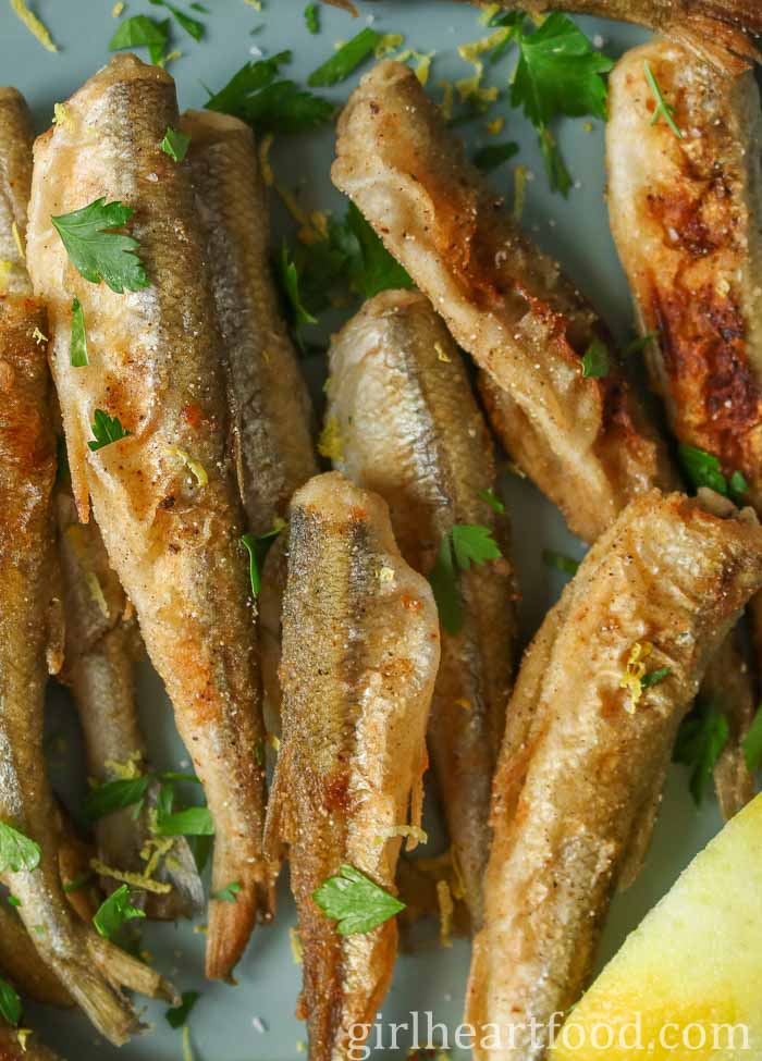 Close-up of fried smelt garnished with chopped parsley.