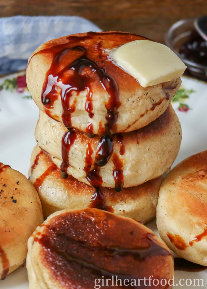 Stack of toutons with a dab of butter over top and drizzled with molasses.