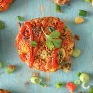 Pinto bean fritter garnished with green onion, hot sauce and cilantro.