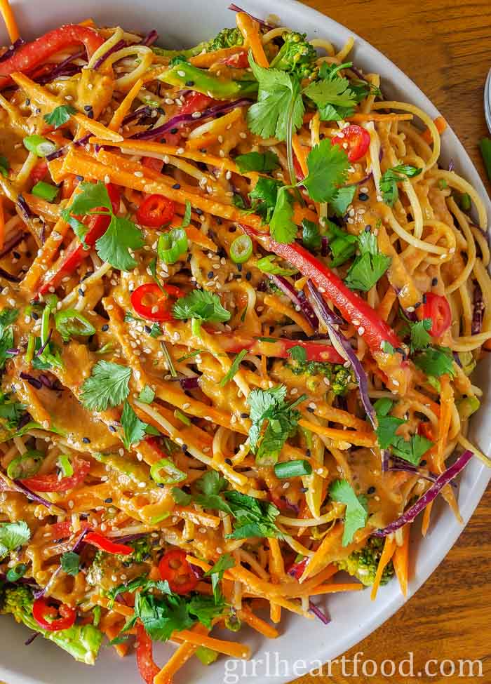 Close-up of peanut noodles and vegetables in a dish.