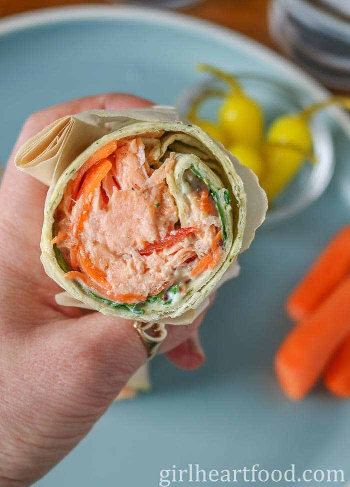 Hand holding a salmon wrap.