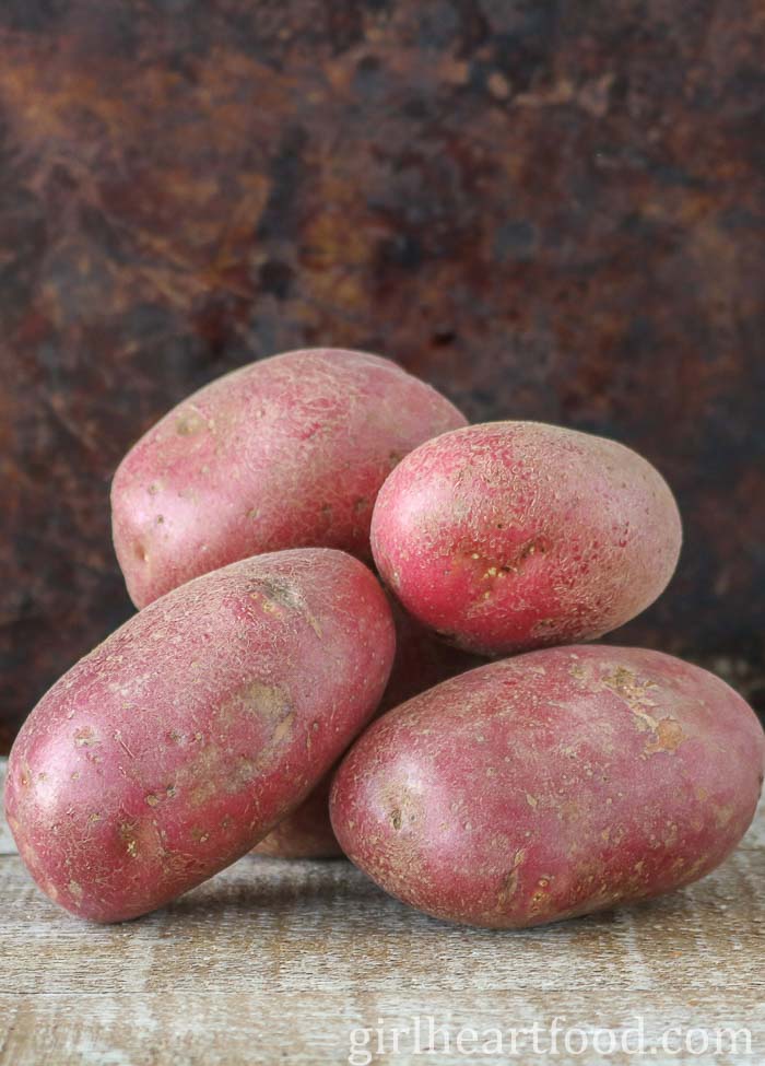 Stack of uncooked and unpeeled red potatoes.