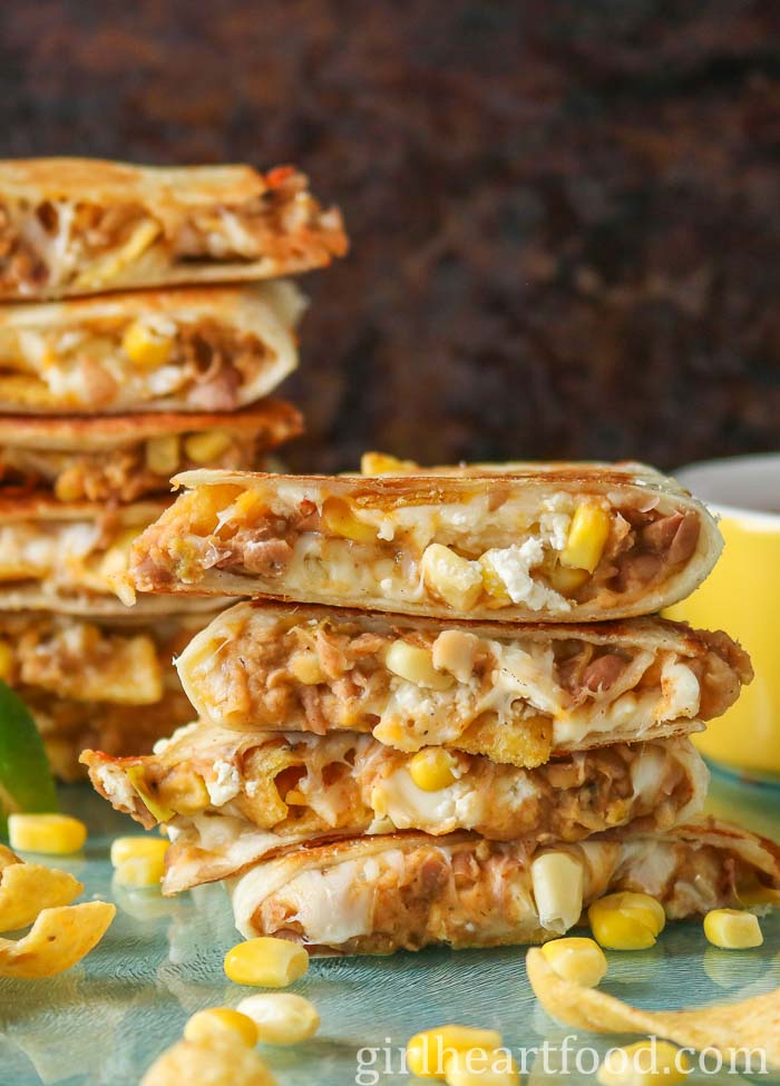 Stack of four refried bean quesadillas with a taller stack behind it.