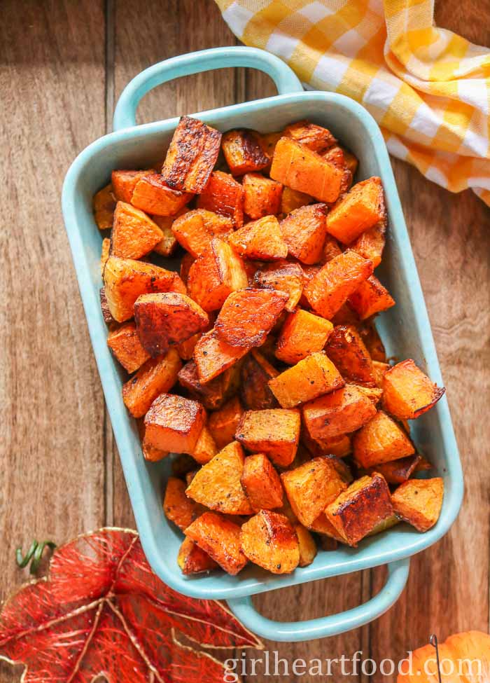 Cubes of roasted butternut squash in a blue rectangular dish.