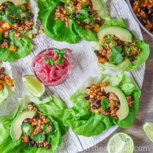 Platter of tofu lettuce wraps with a dish of pickled red onion in the centre.