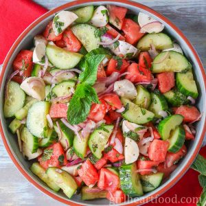 Bowl of watermelon cucumber salad with bocconcini and mint.