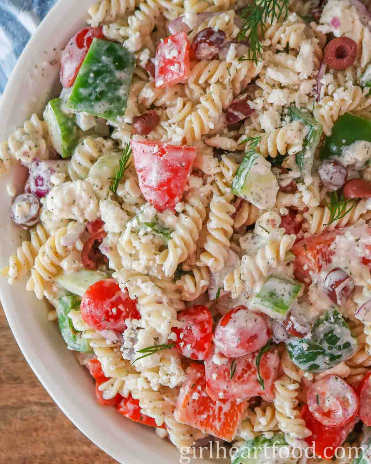 Close-up of creamy Greek pasta salad in a bowl.