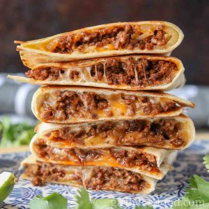 Stack of six cheesy ground beef quesadillas.