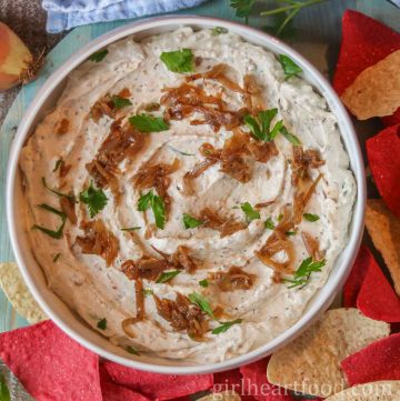 Bowl of homemade onion dip next to some chips.