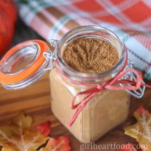 Jar of homemade pumpkin pie spice with a ribbon tied around it.