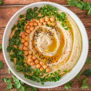 Bowl of hummus garnished with toppings.