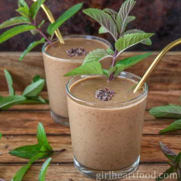 Two glasses of chocolate mint smoothie, one in front and one behind.