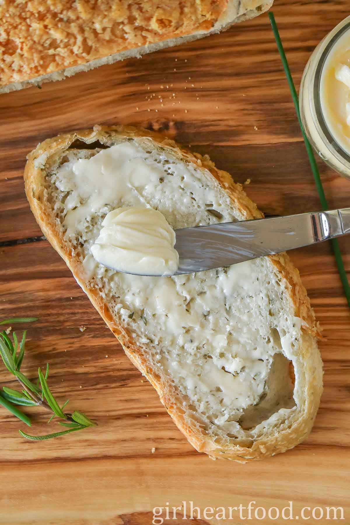 Slice of buttered bread with a butter knife resting on top.