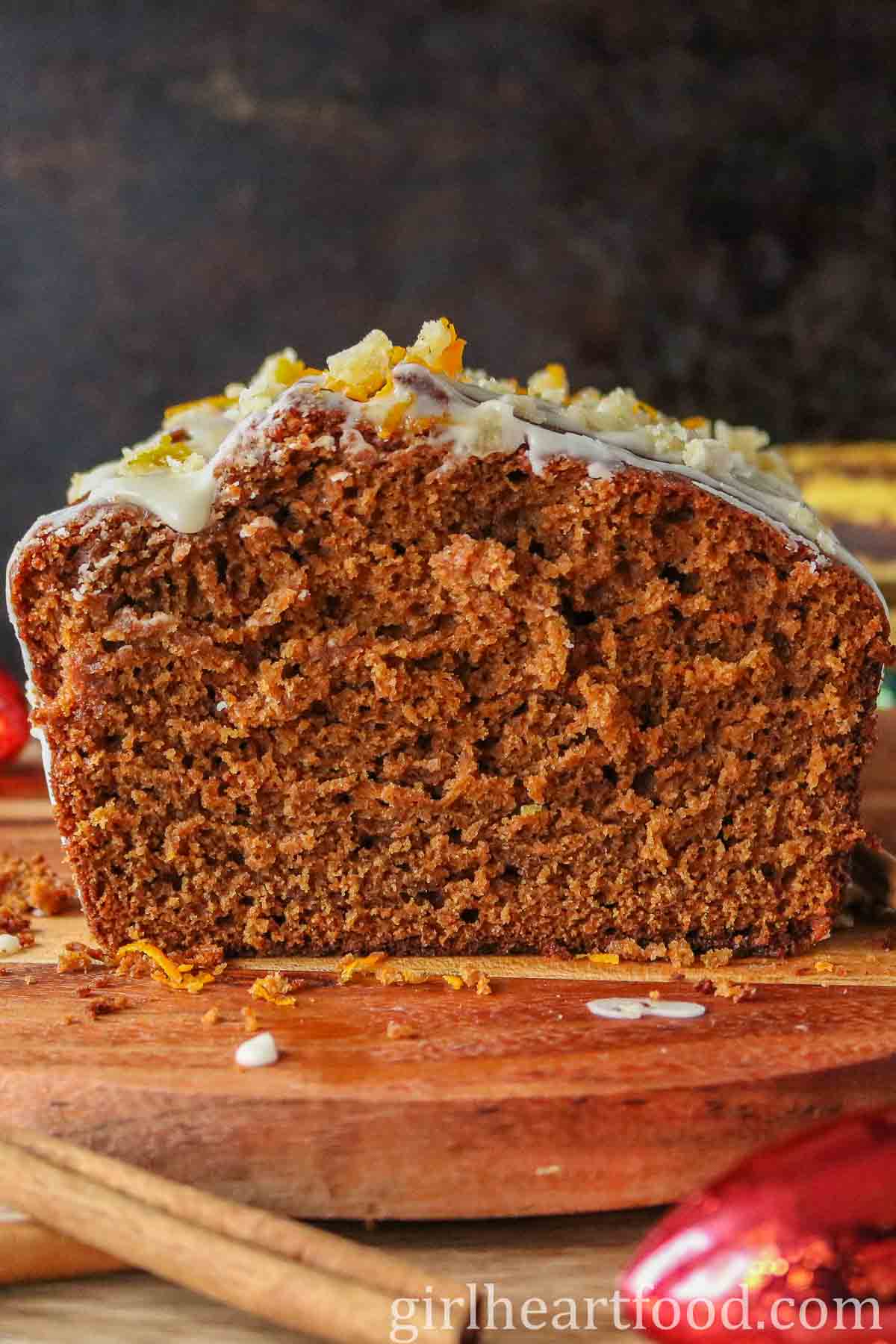 Cut icing sugar glazed banana gingerbread loaf, showing the interior texture.