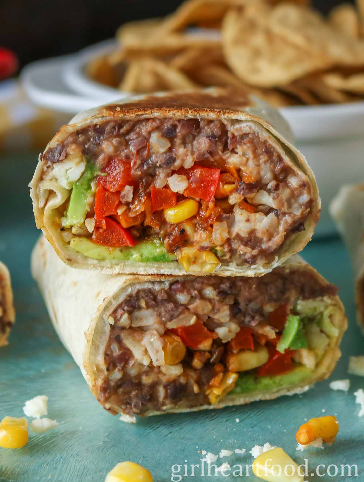 Close-up of a stack of two halves of a refried bean burrito.
