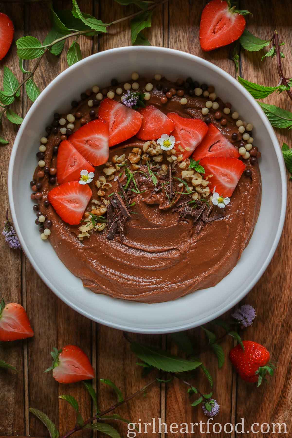 Bowl of chocolate hummus garnished with toppings.