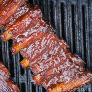 Rack of barbecue sauce covered pork ribs on the grill.