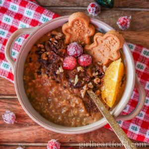 Bowl of gingerbread steel-cut oats garnished with festive toppings.