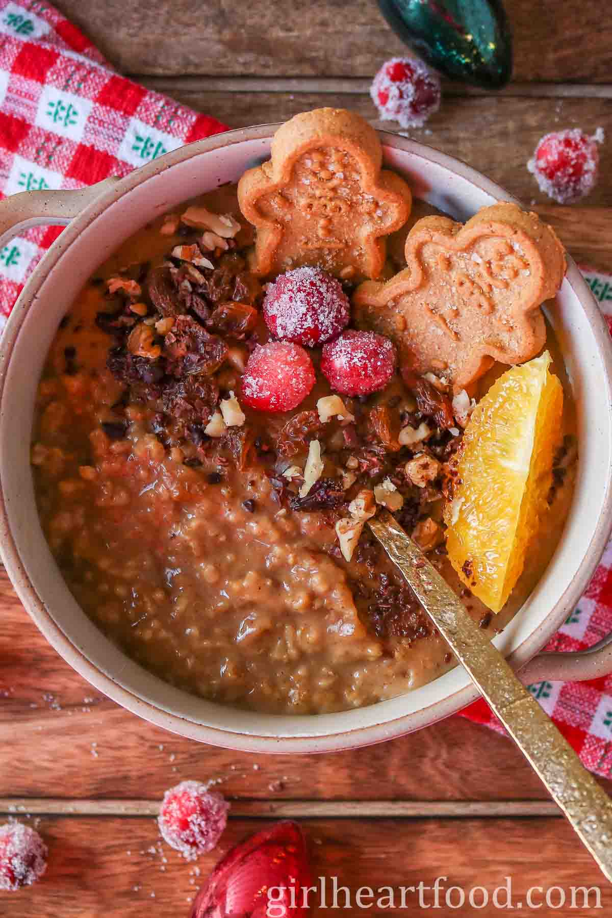 Bowl of gingerbread steel-cut oats garnished with festive toppings.
