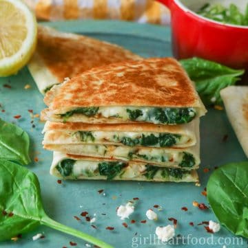 Stack of four cheesy spinach quesadillas.