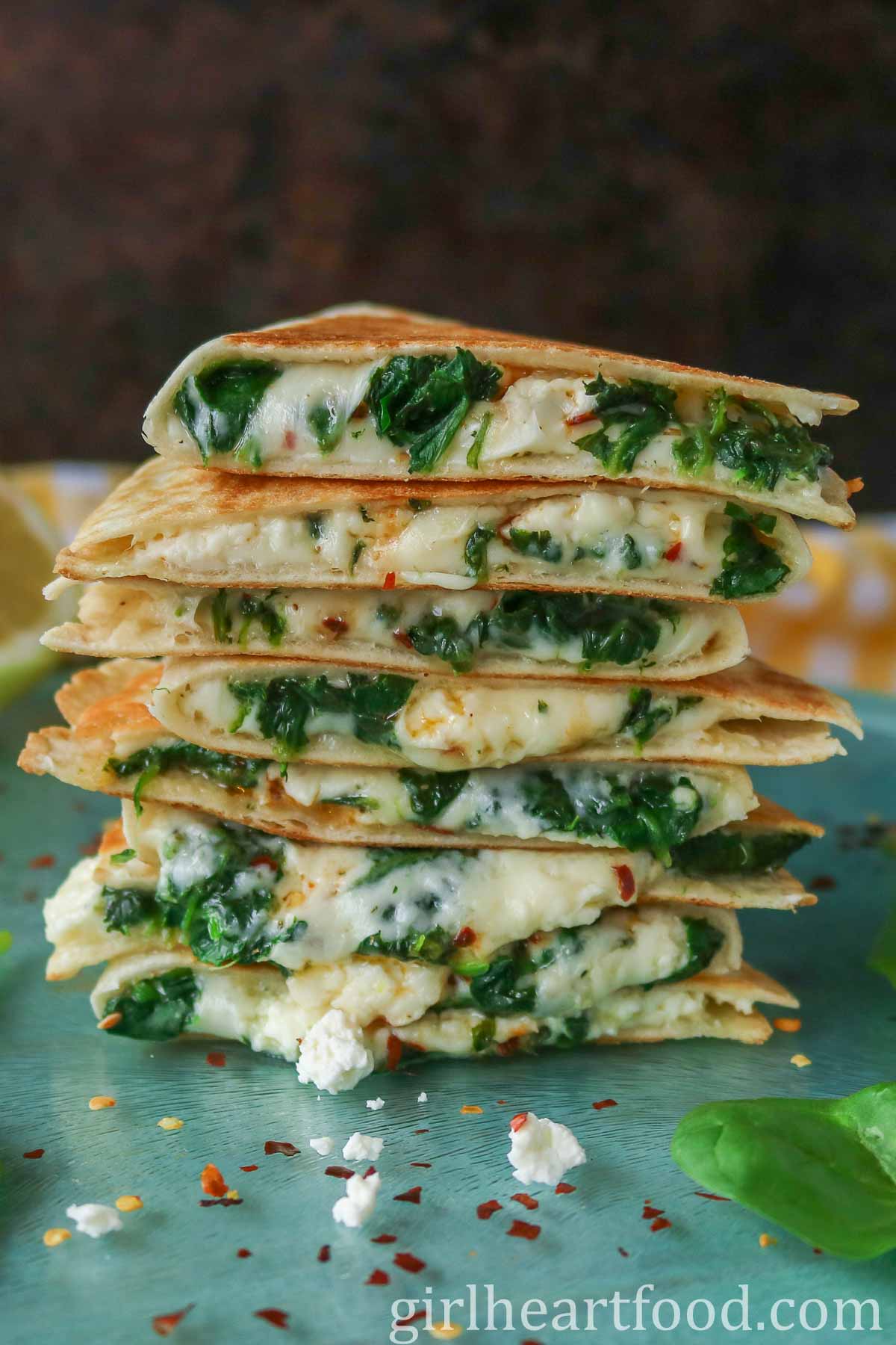 Stack of eight cheesy spinach quesadillas.