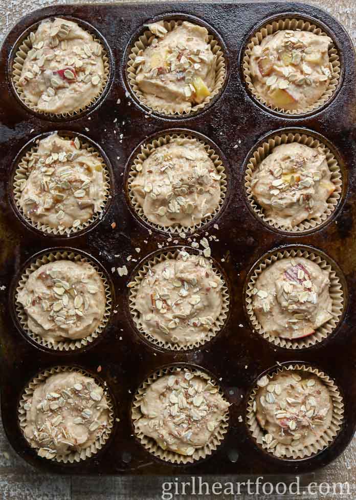 Peach muffin batter with oats in a muffin pan before being baked.