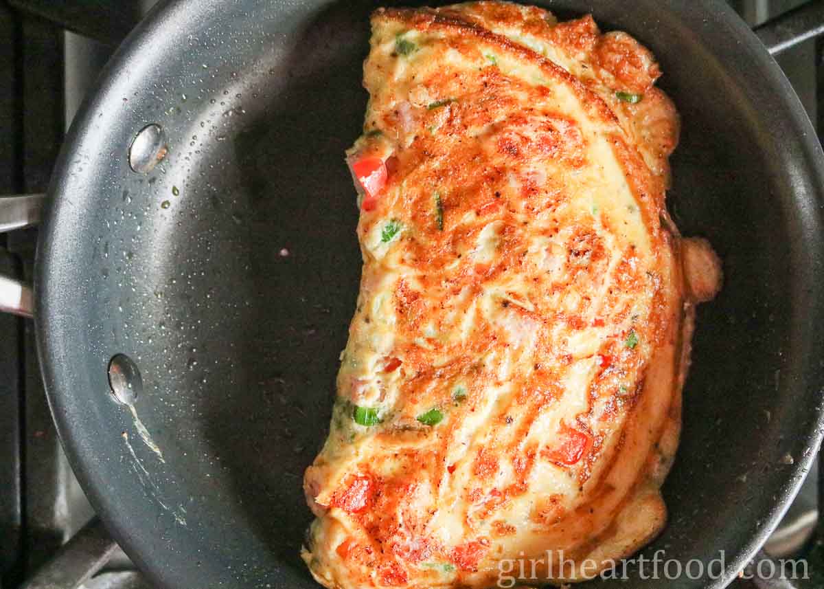 A cooked Western omelette in a non-stick fry pan.
