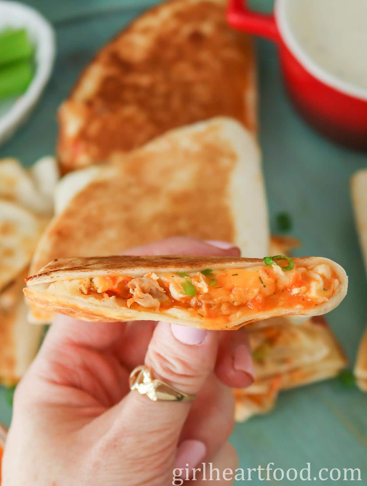 Hand holding a buffalo chicken quesadilla.