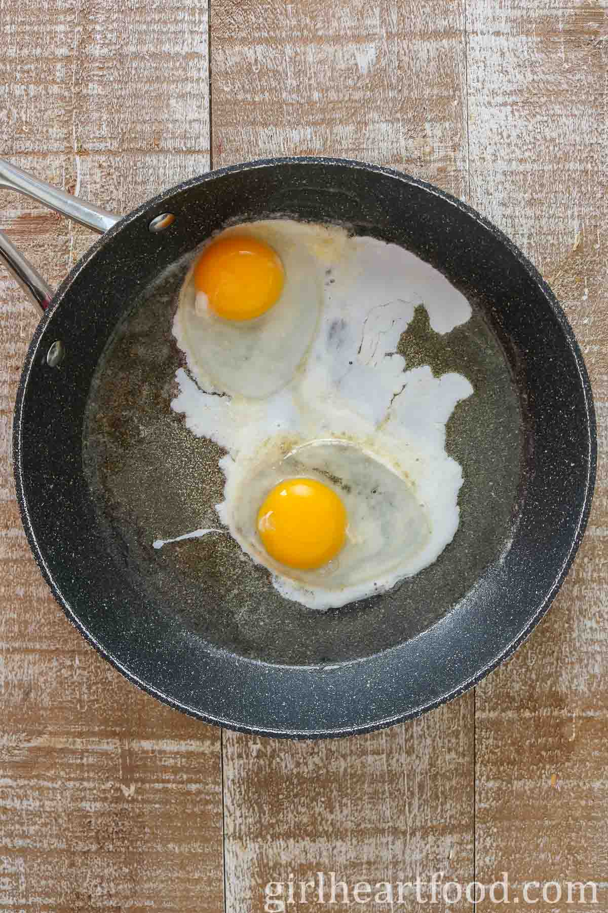 Two eggs in a frying pan.