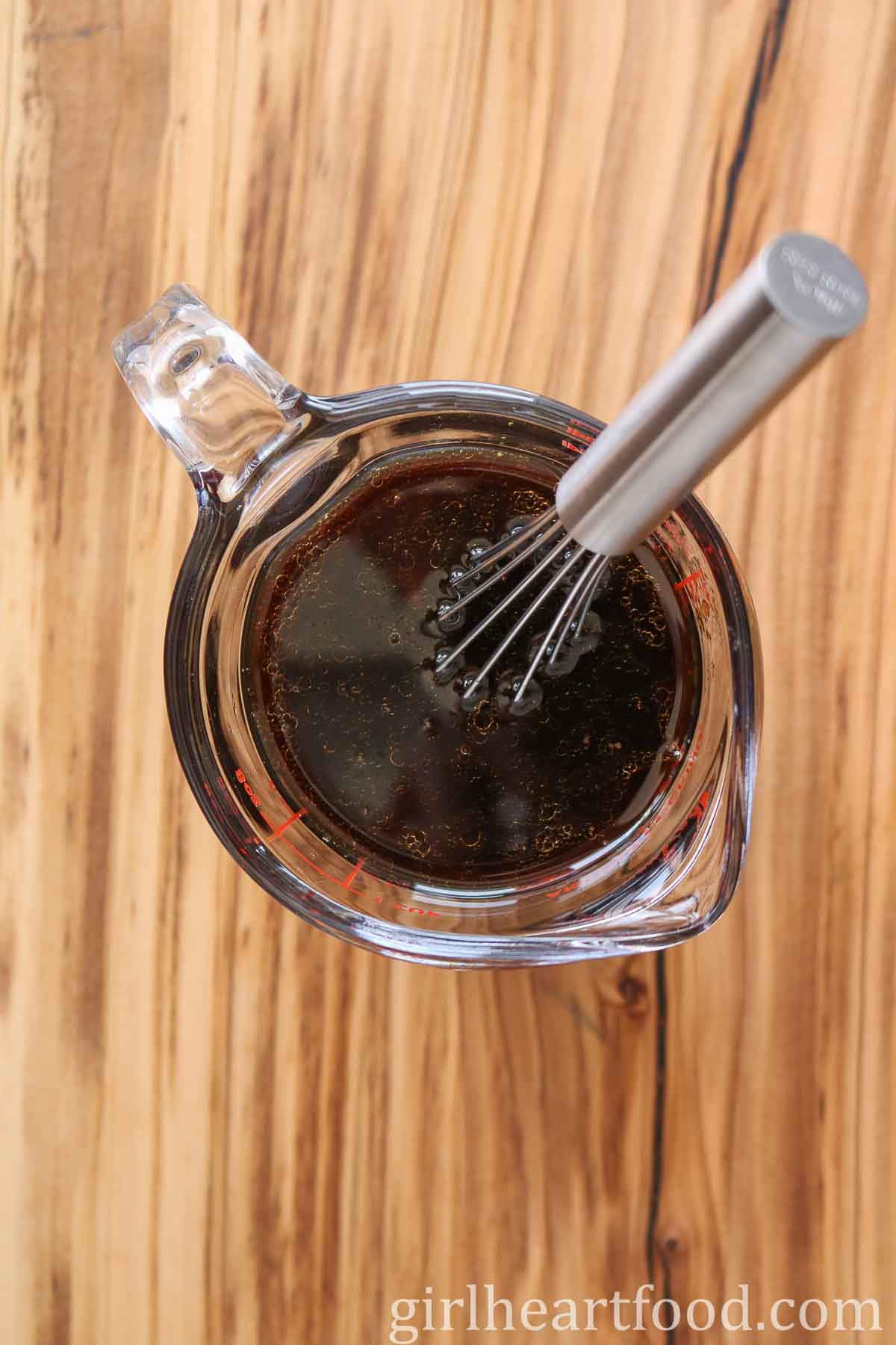 Stir-fry sauce in a measuring cup with a small whisk in it.