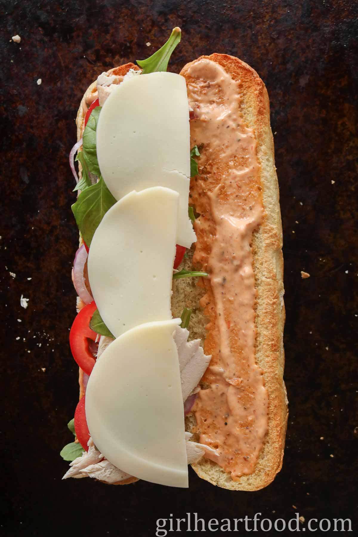 Baguette sandwich before the top bun is placed over the bottom bun.