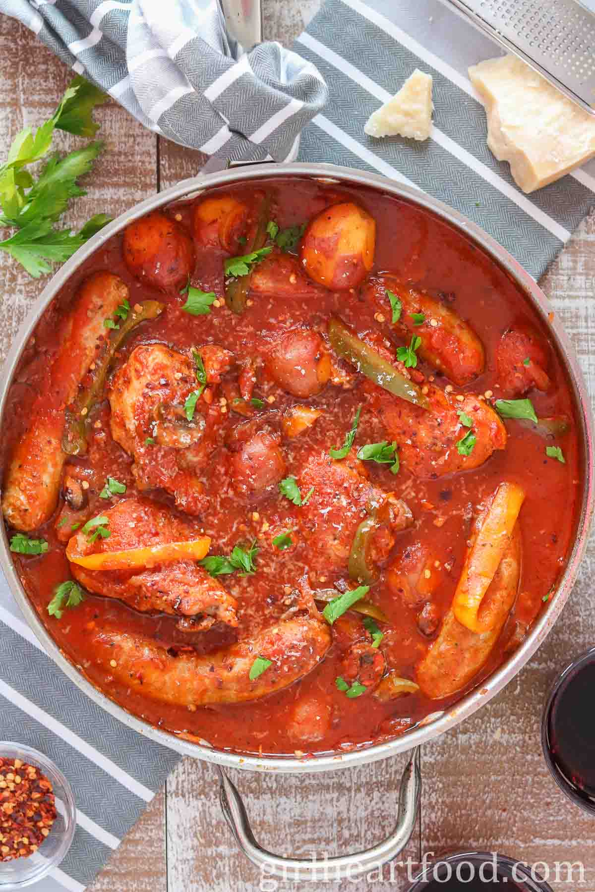Pan of chicken, sausage, peppers and potatoes in tomato sauce.