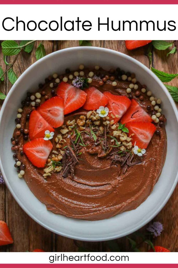 Bowl of chocolate hummus garnished with toppings.