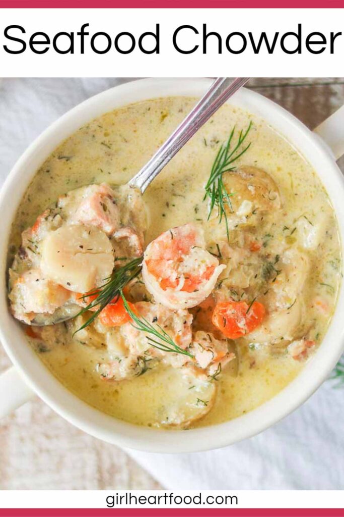 Bowl of creamy seafood chowder with a spoonful of the chowder resting on top.