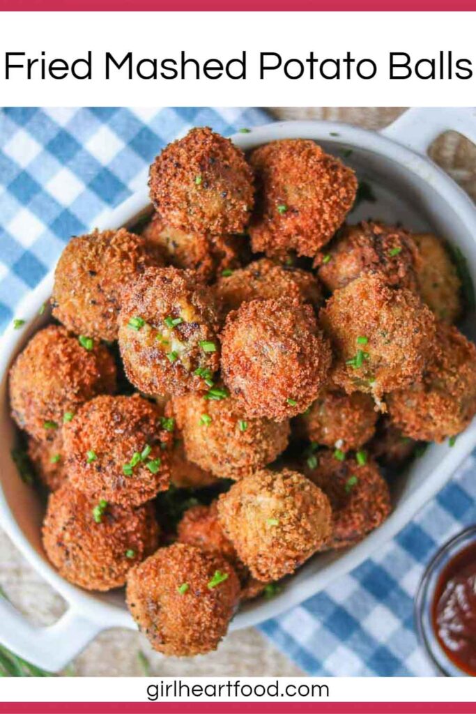 Fried mashed potato balls in a dish garnished with chives.