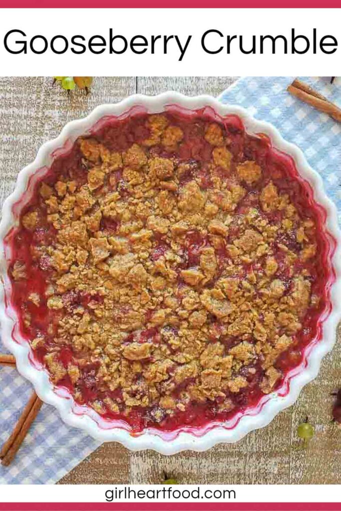 Gooseberry crumble in a dish, sitting on a blue and white checkered cloth.