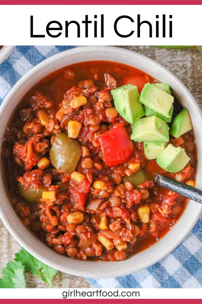 Bowl of lentil chili topped with diced avocado.