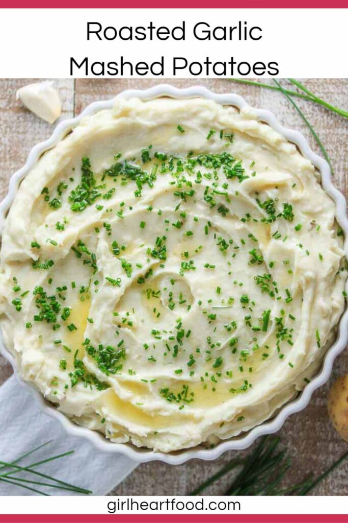 Dish of garlic mashed potatoes garnished with chives and melted butter.