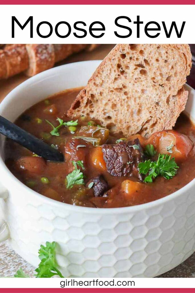 Close-up of a bowl of moose stew with a slice of bread and spoon dunked into it